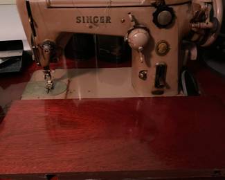 Singer sewing machine in mahogany cabinet that doubles as a desk