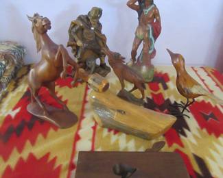 Wooden carved items, two in back near wall are some type of resin.