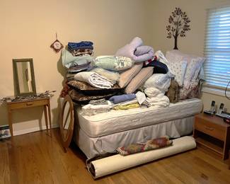 On this bed, you can see a large collection of bedding and pillows. Come take a look! Also, the makeup table is cute.