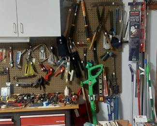 Wall of sm hand tools, clippers, hedge trimmer, rakes, shovels, American flag, etc.