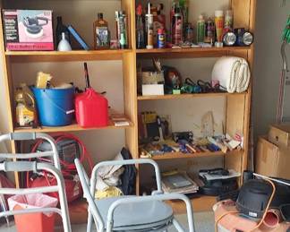 Shef full of painting supplies cleaning products, gas can, shop vac, walker, bedside commode and other goodies in garage