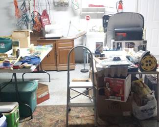 Garage shot - coolers, sewing machine in wood cabinet, exterior extension cords, step stool, tool box, etc.
