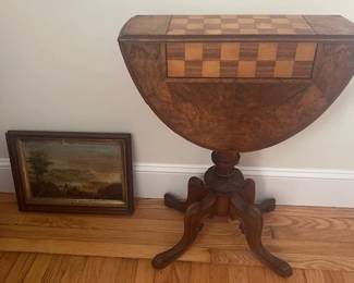 Inlaid gaming table and an old oil painting depicting people on the beach