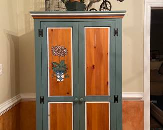 Beautiful custom painted armoire with hanging rod, used as a coat closet in the foyer