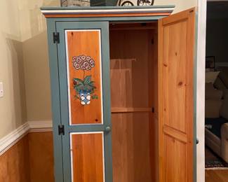 Beautiful custom painted armoire with hanging rod, used as a coat closet in the foyer