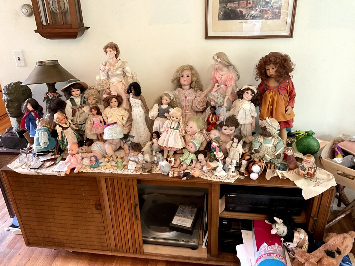 Collectible dolls of all kinds on top of MCM Stereo unit with Vintage Electronics