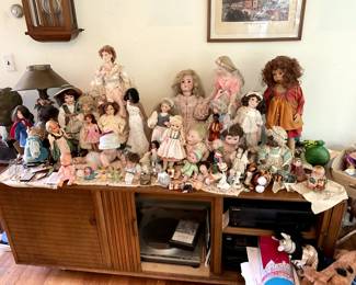 Collectible dolls of all kinds on top of MCM Stereo unit with Vintage Electronics