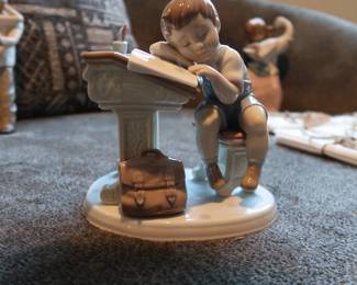 Lladro Porcelain Figurine – “Nap Time at School”
Authentic Lladro figurine, handmade in Spain. Features a young student dozing at a desk with books and a satchel. Glossy pastel finish, excellent detail. Marked on base.
