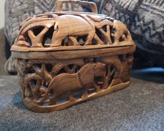 Hand-Carved Wooden Safari Basket
Intricately carved lidded basket featuring elephants, lions, and other wildlife. Lightweight, likely teak or acacia wood. Decorative and functional—use as a bread basket, trinket box, or display piece.
Approx. 8" long
Lid lifts off, carved on all sides