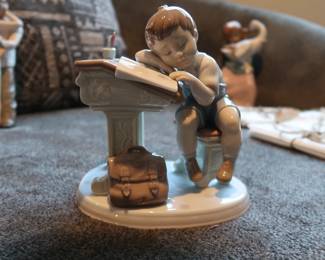 Lladro Porcelain Figurine – “Nap Time at School”
Authentic Lladro figurine, handmade in Spain. Features a young student dozing at a desk with books and a satchel. Glossy pastel finish, excellent detail. Marked on base.