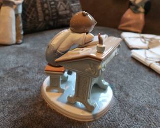 Lladro Porcelain Figurine – “Nap Time at School”
Authentic Lladro figurine, handmade in Spain. Features a young student dozing at a desk with books and a satchel. Glossy pastel finish, excellent detail. Marked on base.