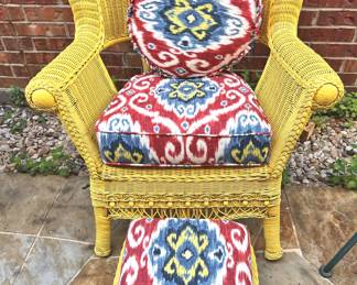 Yellow wicker chair with footstool and pillows
