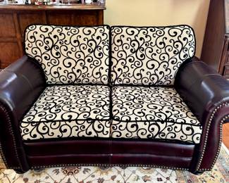$600. Dark leather loveseat with nail head trim and brand-new cushions. 39" x 66" x 38" (to top of back cushion)