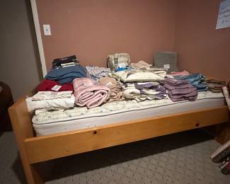 Twin bed with mattress and frame. Assortment or bedding as well
