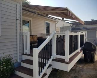 Gorgeous electric awning; vinyl railing; decking