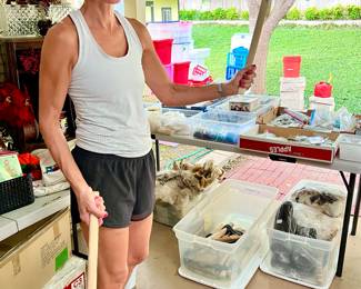 LISA WITH LOTS OF CRAFTING TANDY LEATHER WORKING ITEMS, BEADS, HIDES, AXES, FEATHERS.