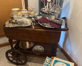 Wooden Tea Cart; Violets Hostess Plates and Mugs; Silver-plate Serving Trays; Wm Rodger’s Silver-plate Tea Set; China Tea Set; Silver-plate Serving Utensils