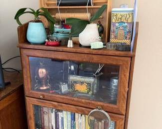 Oak 3 Tier Barrister Bookcase, Potted Orchids, Circa 1980s Pepperidge Farm Assorted Cracker Tin, Metalutil Portugal Copper and Brass Egg Warmer with Chicken Motif, Circa 1940s Mouli Grater, Butterfly Brand Pumpkin Ande Rooney Metal Storage Box, Assortment of Books
