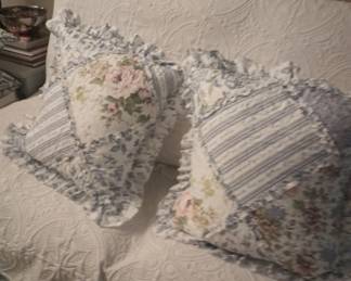 Two feather pillows, blue, white and a bit of pink.