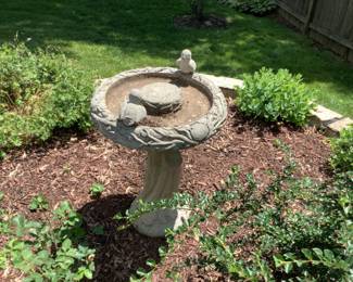 Beautiful cement bird bath with cement birds adorning the top.