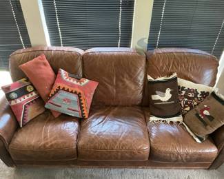 Brown Leather Sofa with Rolled Arms and Decorative Pillows