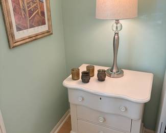 Another view of the white nightstand (2 available), one stainless (brushed finish) lamp and decor