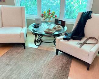 Another view of the oversized occasional chairs (two available), glass round low-profile metal base cocktail/coffee table, and mink hat and purse, and square area rug (taupe and cream) - excellent condition