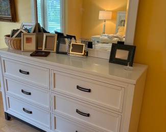 White dresser with mirror, and shown with a curated collection of picture frames