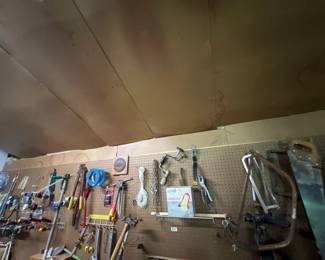 LOT OF TOOLS HANGING ON PEG BOARD