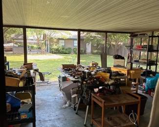 Most of the tools are outside, under a huge covered patio. There are more items in the garage at the back of the photo.