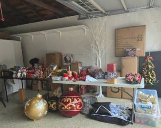 Several Christmas trees in boxes, lights, garland, ornaments, yard decor and a huge Santa!  