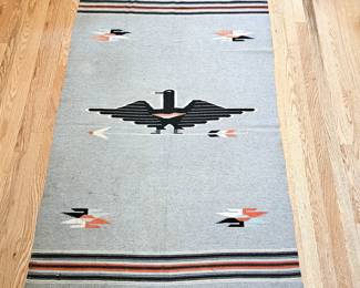 Handwoven wool rug featuring a central thunderbird motif, surrounded by arrow and bird forms 42" x 70"