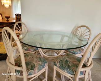 Vintage Kings Rattan Sunrise Dinette with beveled glass top and four rattan framed chairs with floral pattern cushions.