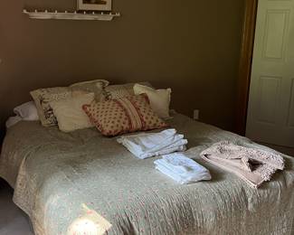 Queen sized bed and comforter set with linens.