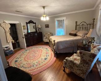 Large rug. Lamp. End table. Floral chairs.