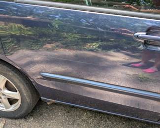 Small amount of rust below door, in front of rear tire (passenger side)
