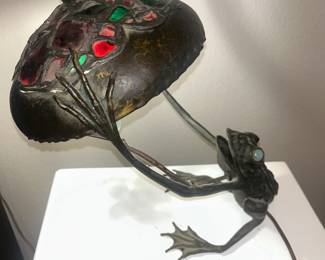 Austrian Art Nouveau bronze figural frog lamp, frog with opal moon glass eyes. Hammered shade with leaded green and ruby chunk glass, 16 inches high.