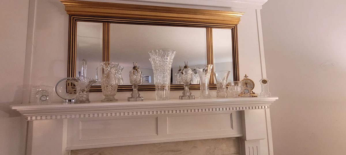 Gilded/Gold framed, 3 panel, beveled mirror above mantel, approx 55"x 27".  2 vintage whale oil glass lamps.  Assorted crystal vases. Assorted table clocks, including 3 Waterford Crystal cloks, and an ImHof Buchere  Gilt solid metal case swiss quartz clock ref# 71-861 (with original Sep 1976 purchase documentation).