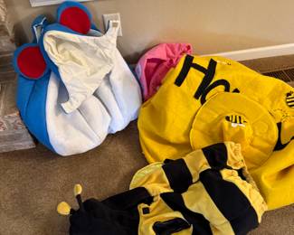 Halloween costumes - children’s costumes are the mouse and the bumblebee in front.  Adult bed in the back. 