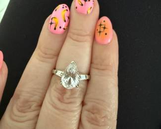 This is a vintage 10K white gold ring with a pear shaped diamond two diamonds on the side