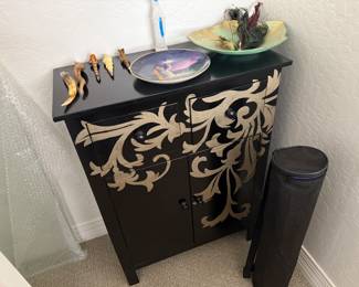 an ornate small cabinet and a yoga matt