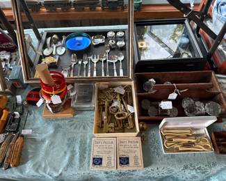 Family Room- Case Table
Bakelite/cloisonné bangles
Brass keys
Sterling flatware 
Tiffany sterling leaf dish
Tiffany stretch glass 
Sterling trinket boxes
Glass knife rests