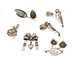 367
A group of Mexican silver floriform brooches
Mid-20th century
Each variously marked for maker, for Mexico and for sterling; further variously marked: [Design number] / [Eagle 16] / [Eagle 1]
Six works in sterling silver including a Hector Aguilar floral sprig brooch, a Margot de Taxco rose bloom brooch (No. 5352), a Los Castillo modernist-style floral sprig brooch with set hardstones (No. 14), two Damaso Gallegos tulip brooches, and a William Spratling ribbon bow brooch with dangling heart, 6 pieces
Largest: 1.75" H x 3" W; Smallest: 1.5" H x 2.25" W
111.7 grams gross
Estimate: $200 - $400