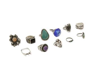 356
A group of silver rings
Mid/late 20th century
Variously marked for maker; four marked for Mexico; seven marked for sterling
Comprising eleven rings in various designs, some with set stones such as onyx, amethyst, turquoise, variscite, including a Matl carved obsidian mask ring, a set cabochon amethyst ring, a Brutalist-style ring with set opal and adjustable shank, and a large Mexican silver cocktail ring with faceted blue glass stone, 11 pieces
Largest ring size: 8.5; smallest: 4.25
87.4 grams gross
Estimate: $400 - $600
