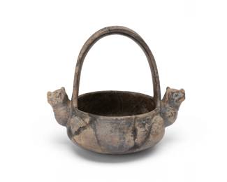 175
Circa 900 CE; Colombia
A Pre-Columbian Tairona pottery effigy vessel
The blackware ceramic basket-form vessel with large handle, featuring opposed mammalian protrusions with incised facial features
7.875" H x 8.625" W x 6.5" D
Estimate: $300 - $500