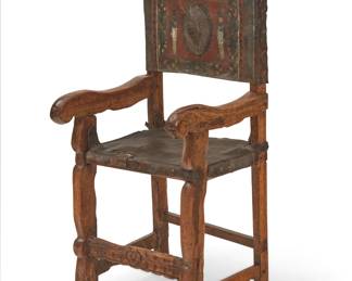 258
17th/18th Century; Northern Andes Region
A Spanish Colonial Sillon de Frailero chair
Likely Peruvian, the friar's chair with carved wood frame and tooled and painted leather seat and back, the back depicting a peacock within a wreath centering two soldier figures, all within a floral border
47.5" H x 21" W x 19" D
Estimate: $1,000 - $1,500