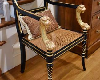 Regency style ebonized caned chair with gilt lion head arms