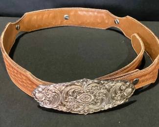 Tooled Leather Belt With A Silver Buckle