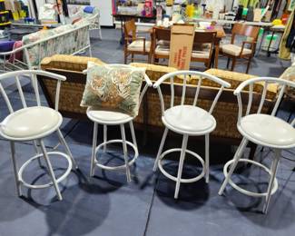 Four white swivel barstools.