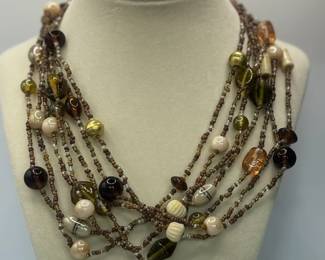 Necklace with seven (7) strands of multi-color beads: brown, beige, light green, peach. Approximately 16-1/2"
USA Shipping Only.